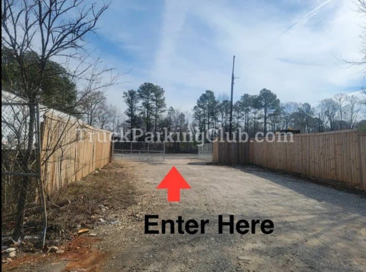 The yard entrance: a gravel drive between two wooden fences leading to the gate.